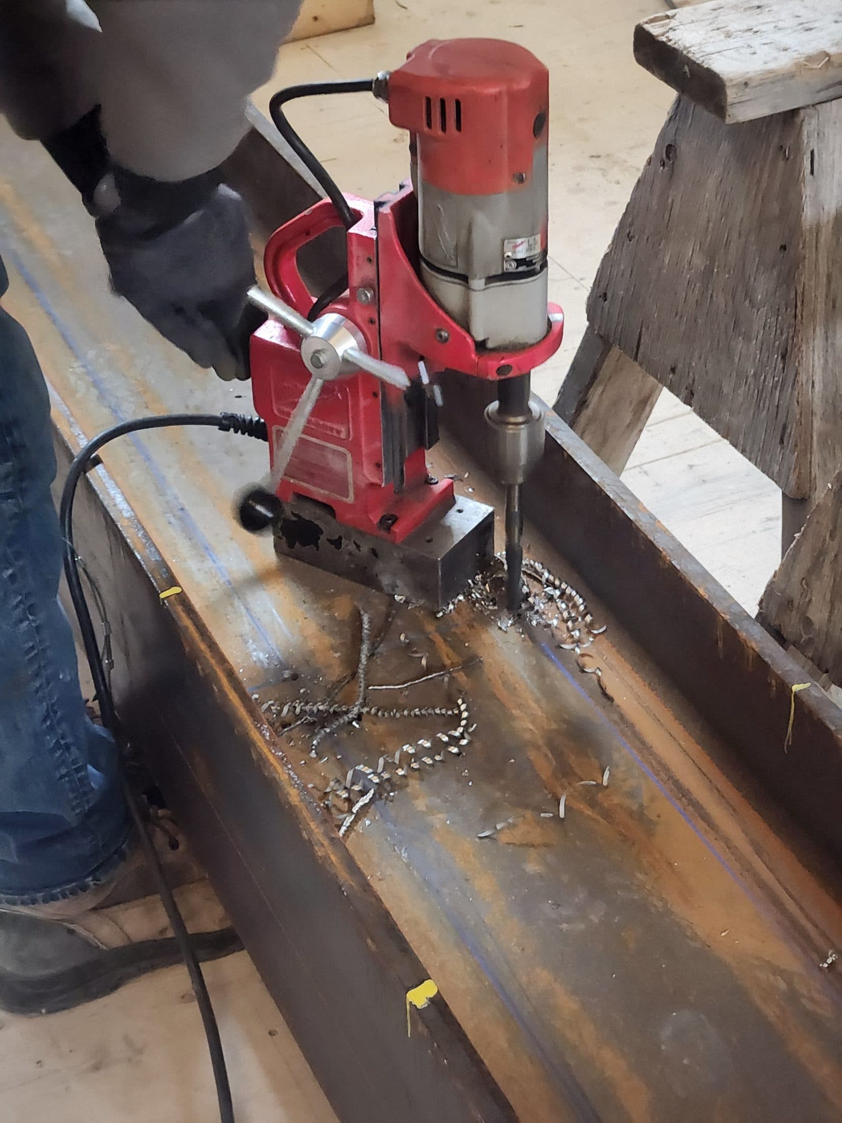 Magnetic drill boring bolt holes through a steel beam on site