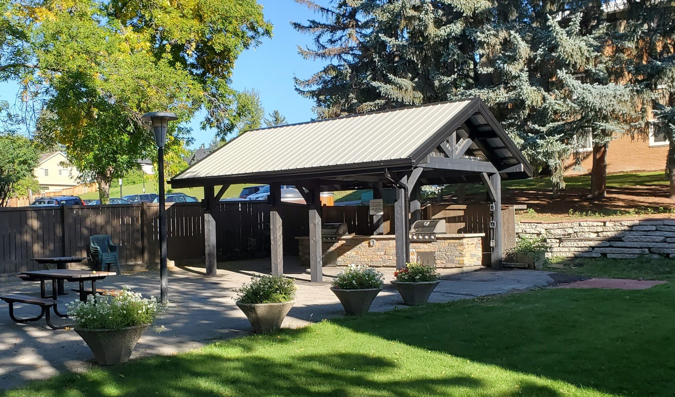 Timber pavilion with a metal roof in a landscaped yard